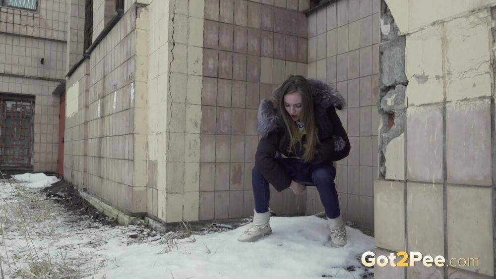 White girl Vika takes an urgent piss on snow-covered ground next to a building - #8