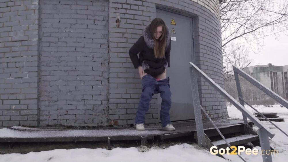 White girl pulls down her jeans to pee in the snow behind a building - #2