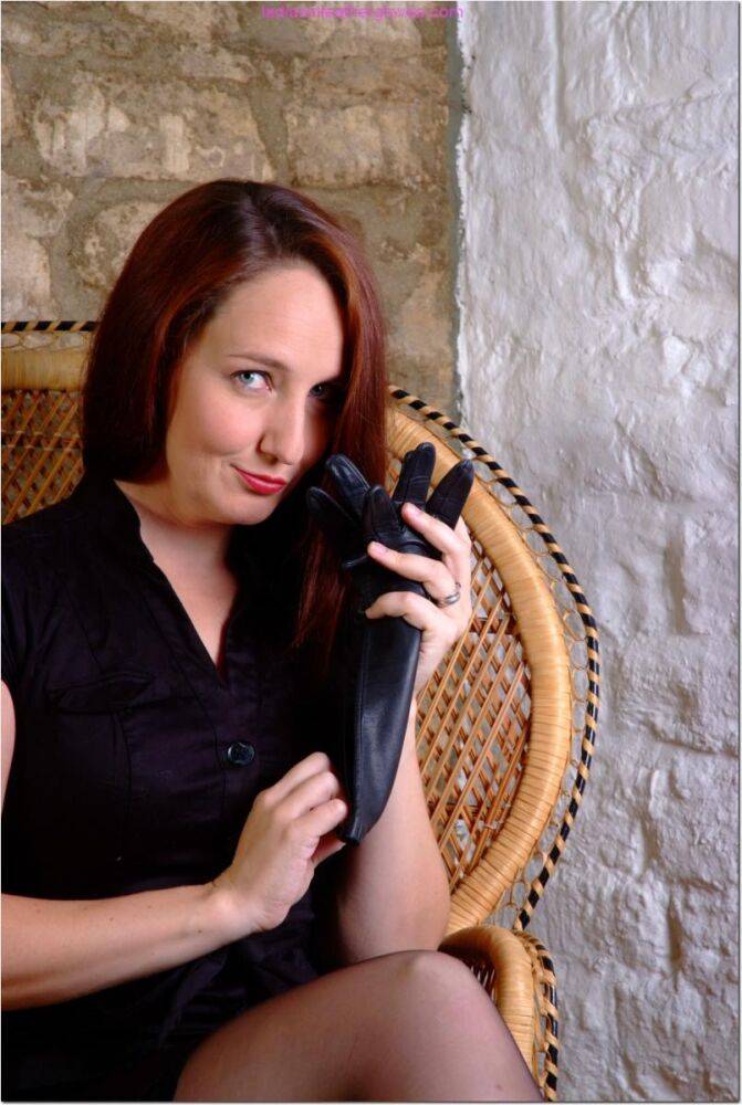 Clothed redhead Sammi dons a pair of black leather gloves in a wicker chair - #7