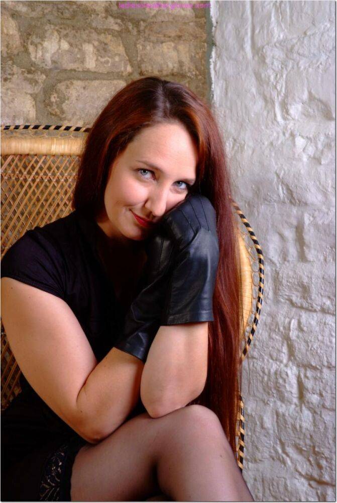 Clothed redhead Sammi dons a pair of black leather gloves in a wicker chair - #8