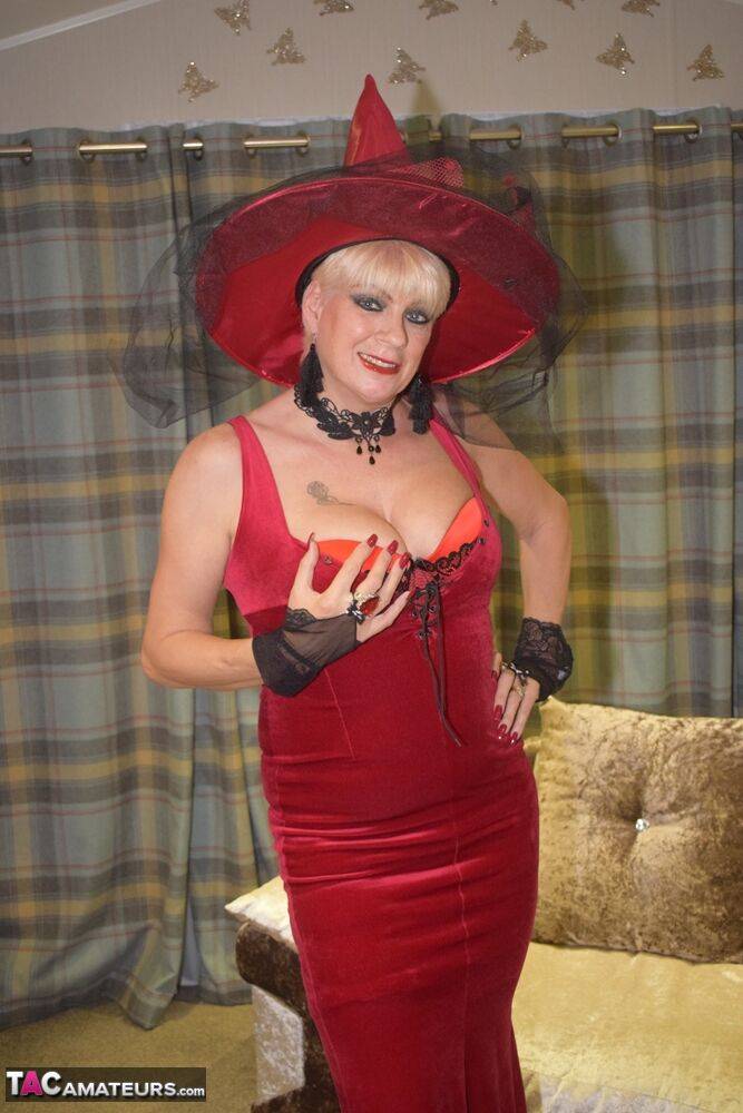 Older blonde removes a red velvet dress pose nude in a witch's hat and hosiery - #1