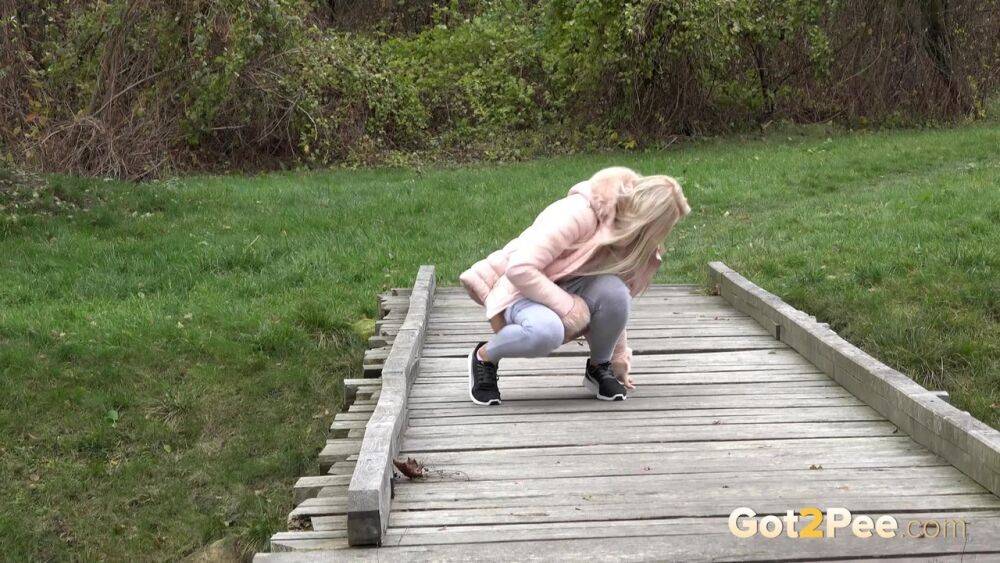 Blonde Katy Sky shows her bald beaver while squatting outside for a pee - #2