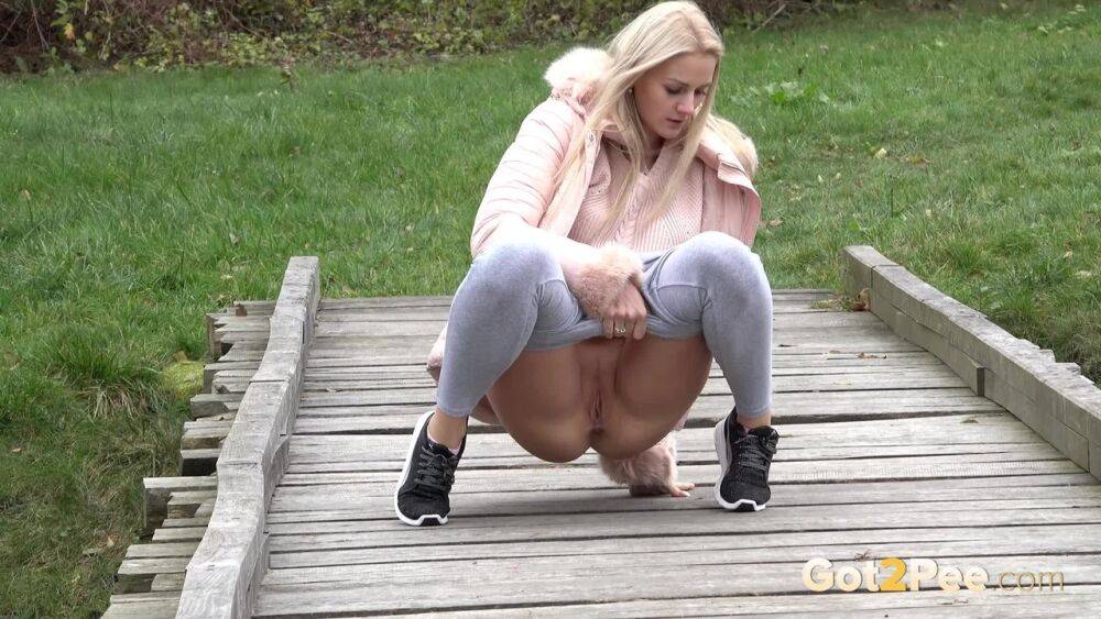 Blonde Katy Sky shows her bald beaver while squatting outside for a pee - #15