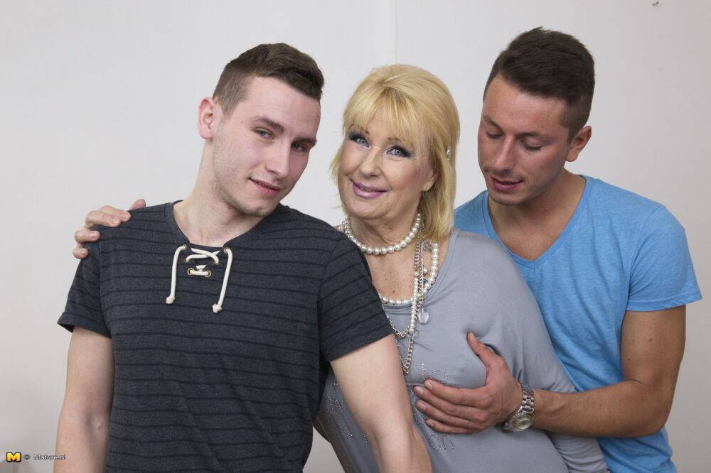 Blonde mature woman gets two boy toys to suck her big tits in old young 3some - #8