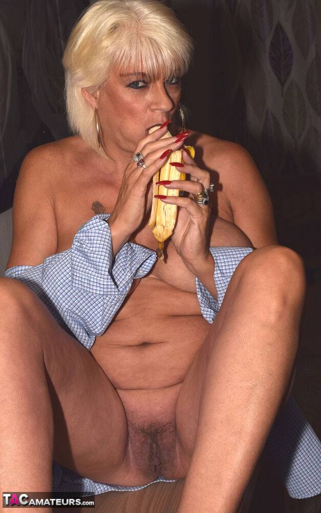 Older blonde Dimonty eats a banana with her shirt undone in black heels - #11