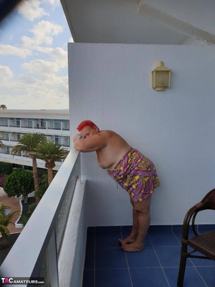 Obese nan with spiky red hair unveils her tits on balcony before posing naked - #14