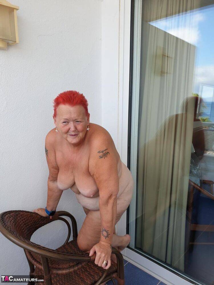 Obese nan with spiky red hair unveils her tits on balcony before posing naked - #10