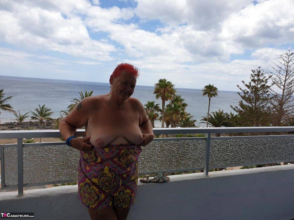 Obese nan with spiky red hair unveils her tits on balcony before posing naked - #3