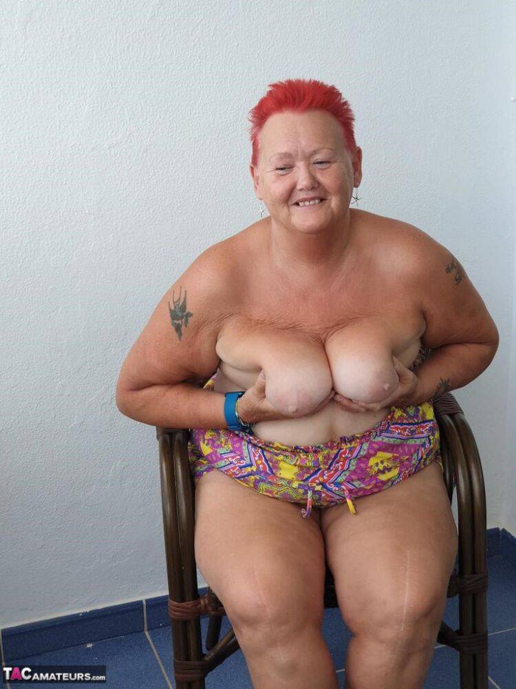 Obese nan with spiky red hair unveils her tits on balcony before posing naked - #1