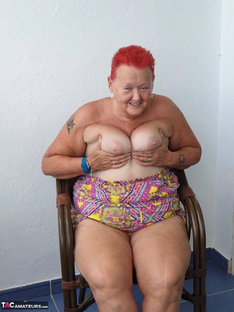 Obese nan with spiky red hair unveils her tits on balcony before posing naked - #7