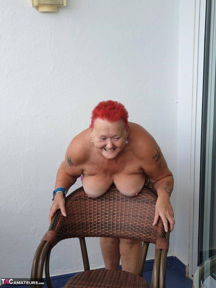 Obese nan with spiky red hair unveils her tits on balcony before posing naked - #9