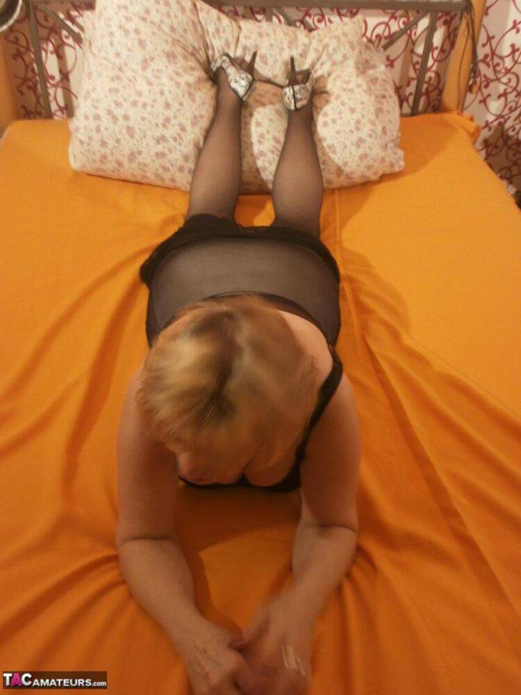 Tipsy hot granny Caro spreading legs on the bed wearing black stockings - #3