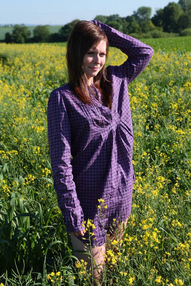 Young redhead gets completely naked in a field of Rapeseed - #5