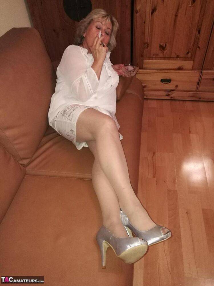 Mature lady exposes her large tits while having a smoke in pantyhose - #1
