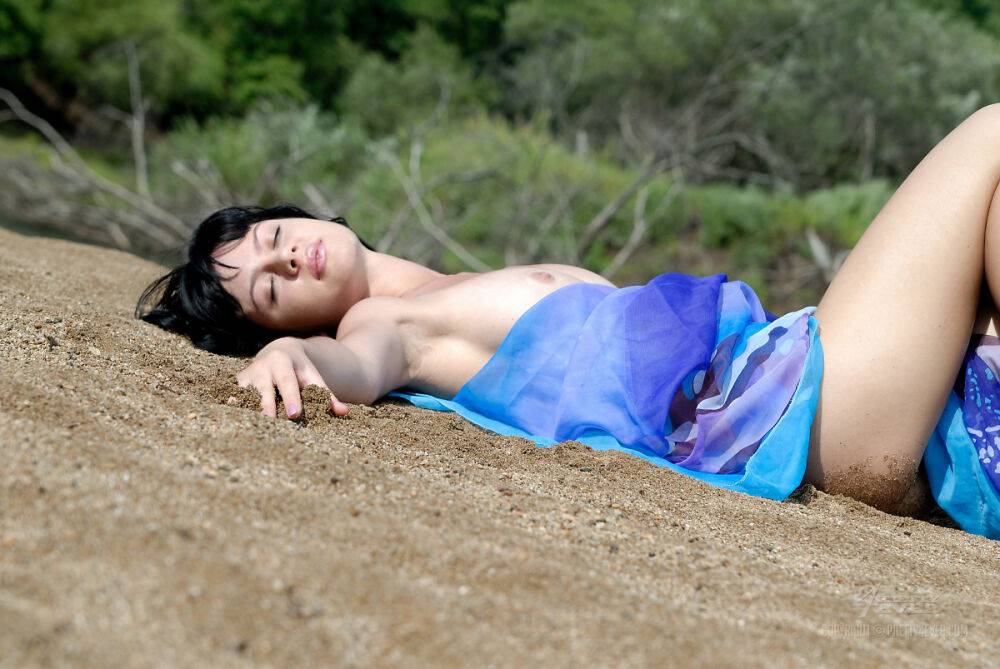 Solo girl with black hair strikes winning nude poses near a body of water - #1