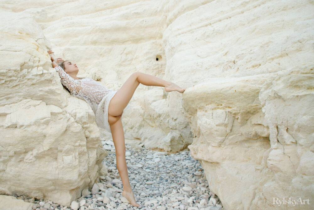 Platinum blonde teen Sofy Bee removes a lace dress to go naked on rocky ground | Photo: 4634737