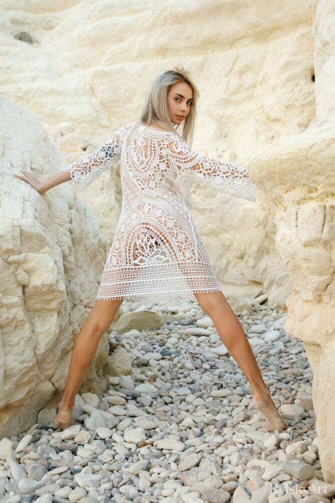 Platinum blonde teen Sofy Bee removes a lace dress to go naked on rocky ground | Photo: 4634832