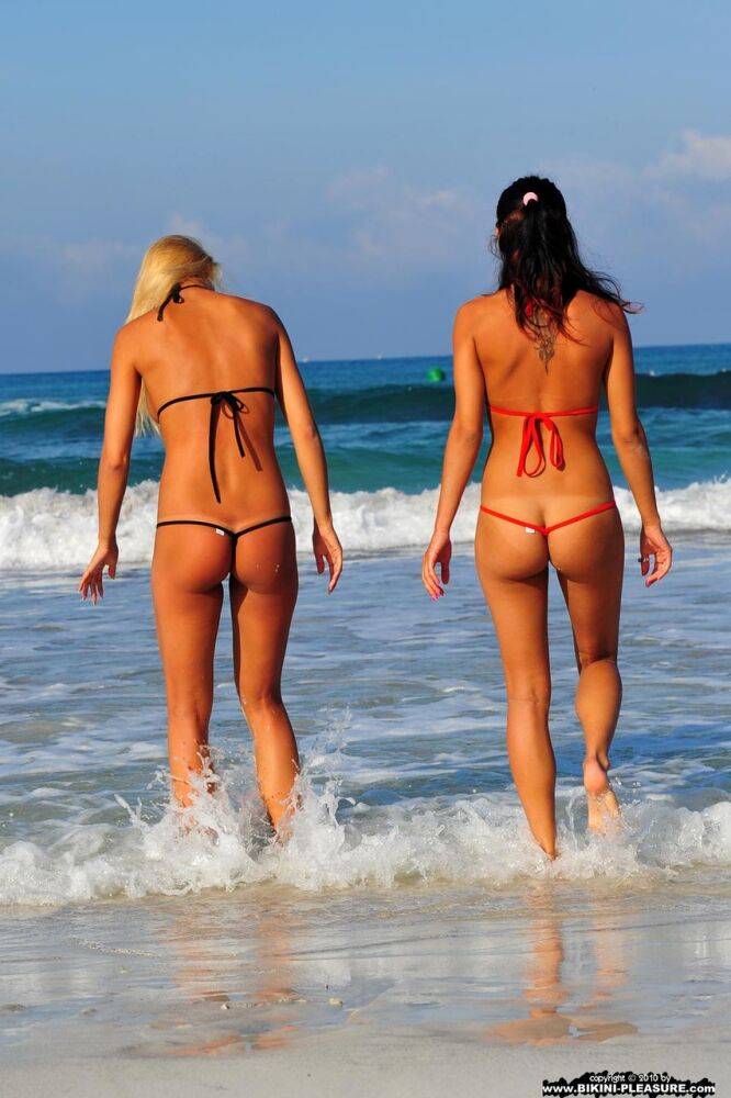 Pretty girls take out their bikinis while walking along a pristine beach - #6