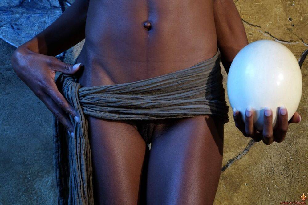 Dark skinned girl Jess holds a large egg while modeling butt naked - #12