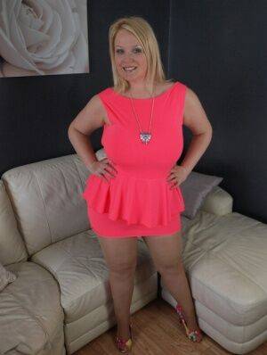 Thick amateur Sindy Bust teases on leather furniture in a short pink dress on nudesceleb.com