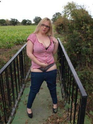 Amateur BBW Sindy Bust exposes her big boobs and twat on a countryside bridge on nudesceleb.com