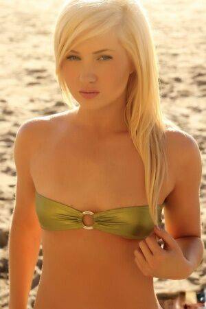 Young looking blonde girl Ashlie Madison cups her flat chest via bikini top on nudesceleb.com