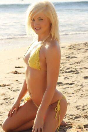 Blonde glamour model Ashlie Madison poses alone on a beach in a yellow bikini on nudesceleb.com