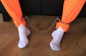 Female prisoner is left alone while cuffed in an orange jumper and white socks on nudesceleb.com