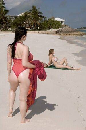 Plump female Christy Mark and her big boobed friend have lesbian sex on beach on nudesceleb.com