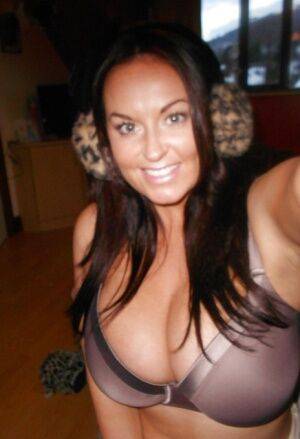 Buxom brunette babe Sarah Nicole Randall posing topless with ear muffs on nudesceleb.com