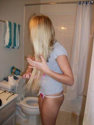 Blonde amateur Elle brushes her hair in glasses and thong while in a bathroom on nudesceleb.com