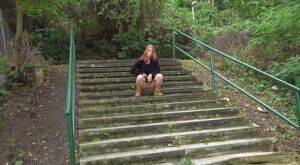 Natural redhead Chrissy Fox squats for a pee on a set of public steps on nudesceleb.com