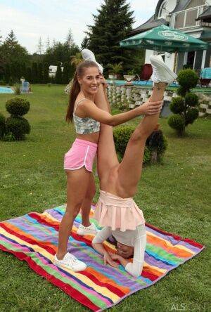 Young lesbians Eveline Dellai & Katy Rose fist pussies during sex on a lawn on nudesceleb.com