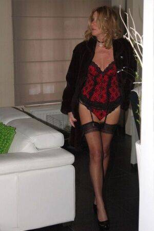 Blonde mature slut Kyra flaunting long legs in red lingerie & black stockings on nudesceleb.com