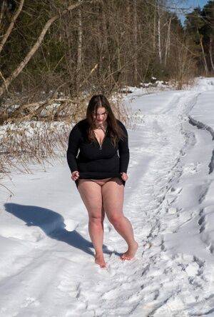 Brunette BBW rids ball gag and ropes while posing nude and barefoot in snow on nudesceleb.com