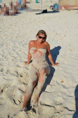 Naked amateur Sweet Susi covers her body in beach sand in sunglasses on nudesceleb.com