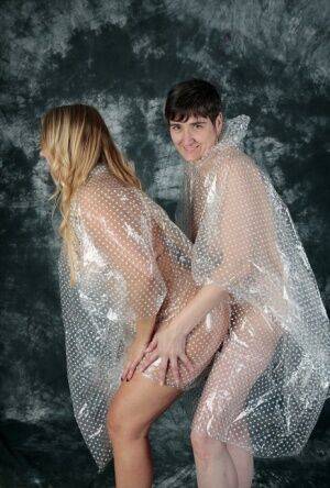 Blonde amateur Sweet Susi and her lesbian lover hump each other in raincoats on nudesceleb.com