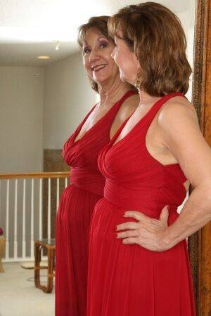 30 plus redhead Lynn doffs a long red dress before pussy play afore a mirror on nudesceleb.com