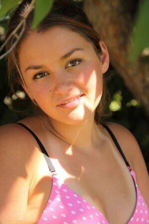 Petite amateur Allie Haze shows her tan lined body in the shade of a tree on nudesceleb.com