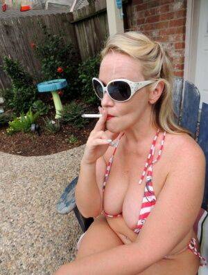 Fat blonde Dee Siren smokes while taking off a bikini in the backyard on nudesceleb.com