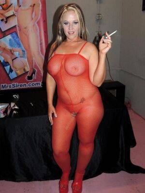 Amateur BBW Dee Siren smokes before facial cumshots in a red bodystocking on nudesceleb.com