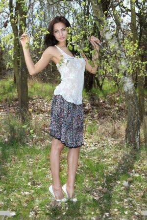 Long legged Michaela Isizzu flashes naked upskirt and poses nude in the forest on nudesceleb.com