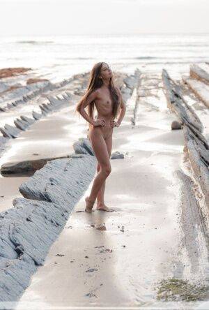 Slim girl Lorena G models totally naked on a seaside rock formation on nudesceleb.com