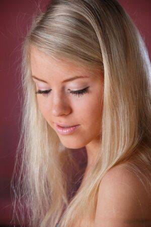 Beautiful blonde teen Barbara D slips out of a dress to pose nude on a chair on nudesceleb.com