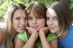 Three young looking girls gets naked on a wooden bench in the countryside on nudesceleb.com