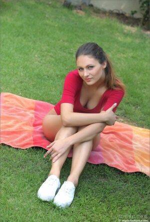 Cute brunette in sneakers posing naked on her knees on the front lawn on nudesceleb.com