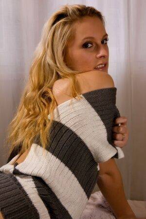 Blonde chick Joe shows her bald pussy in a sweater and black boots on nudesceleb.com