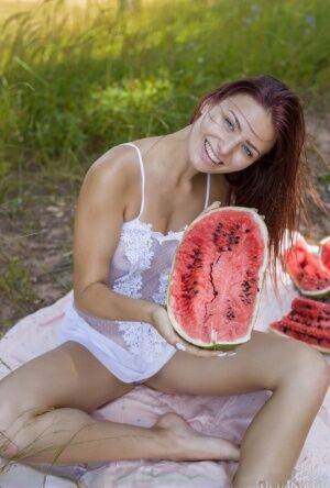 Sweet young girl gets naked while eating a watermelon under a tree on nudesceleb.com