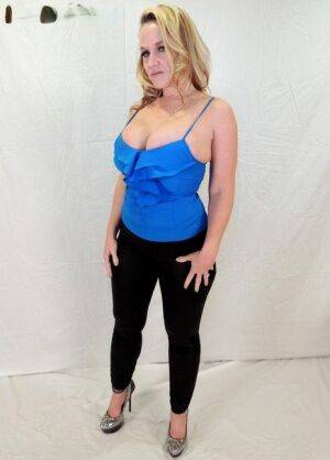 Middle-aged blonde Dee Siren displays her ample cleavage in black leggings on nudesceleb.com