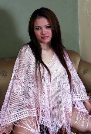 Asian amateur doffs a poncho and panties to pose totally naked on an armchair on nudesceleb.com